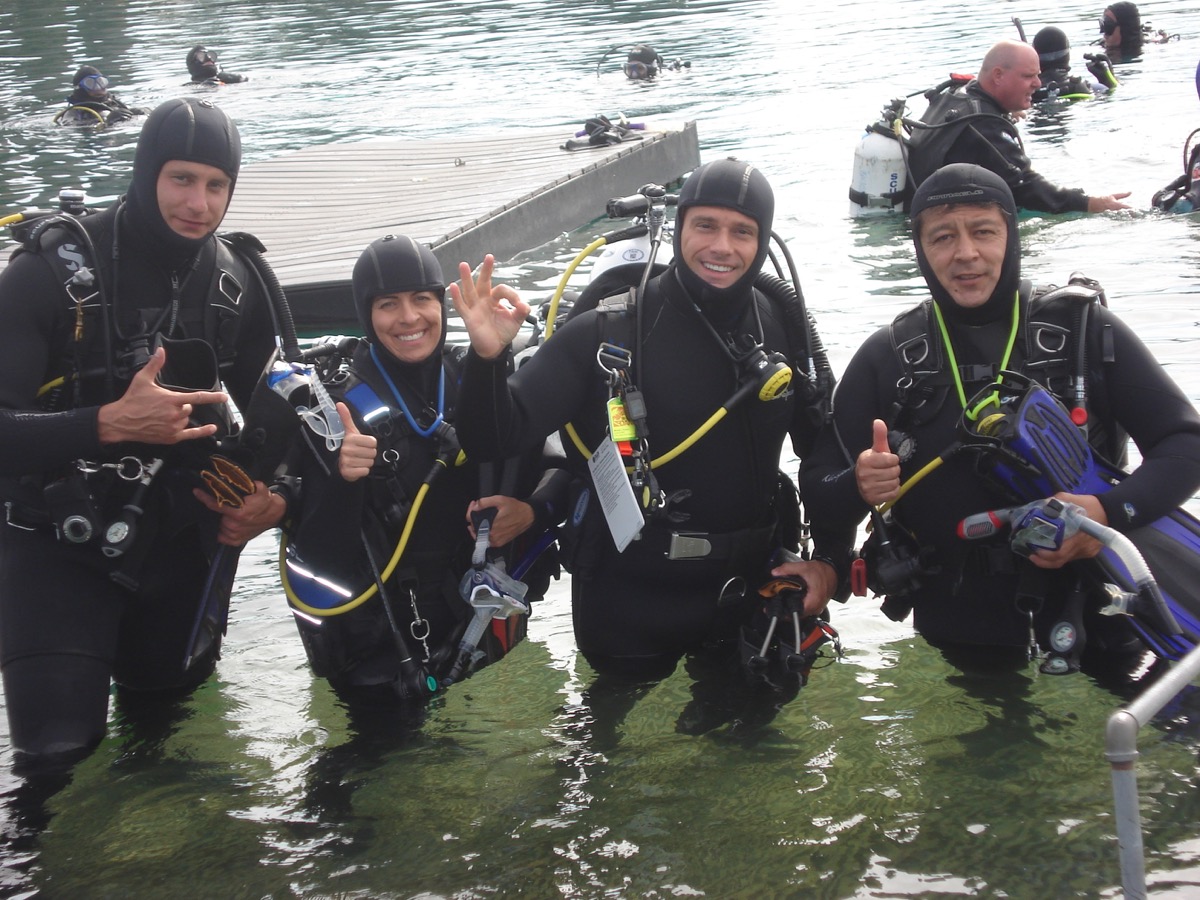 4 people in scuba gear smailing
